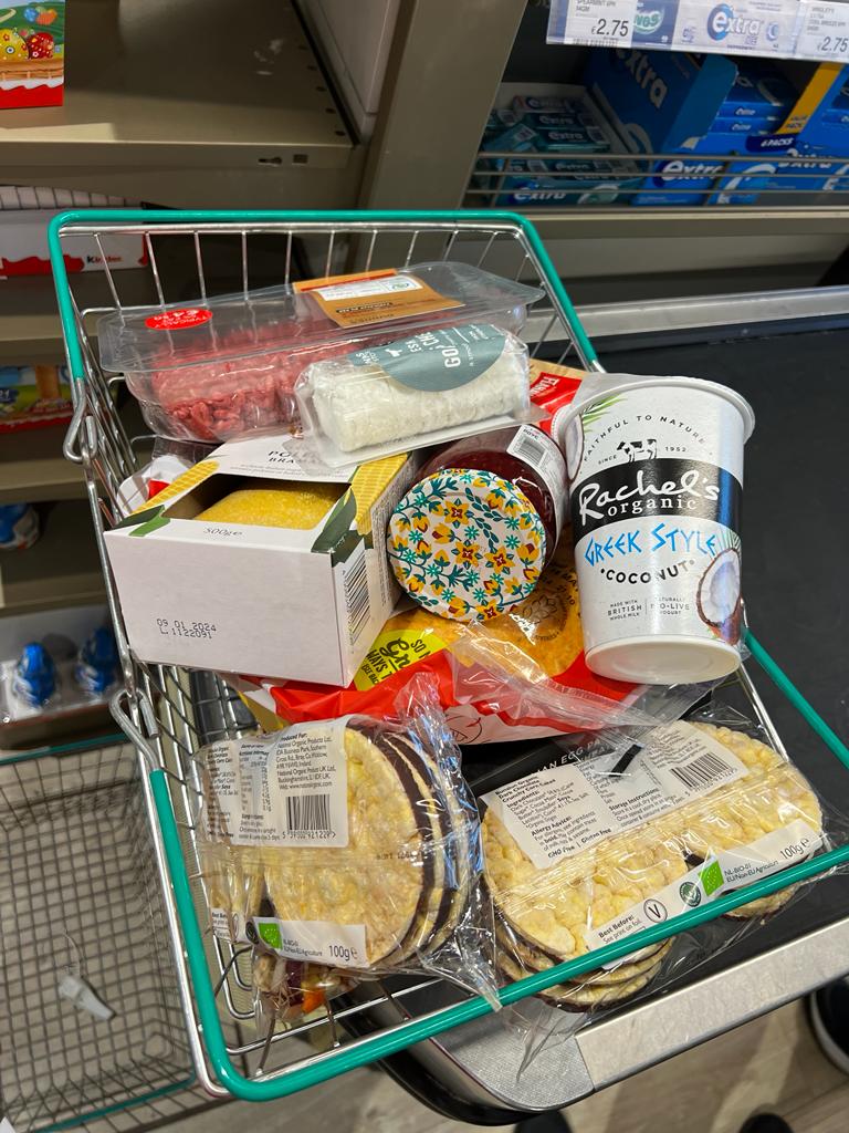 Carrinho de mercado com alimentos variados, mostrando escolhas de uma nutricionista na Europa