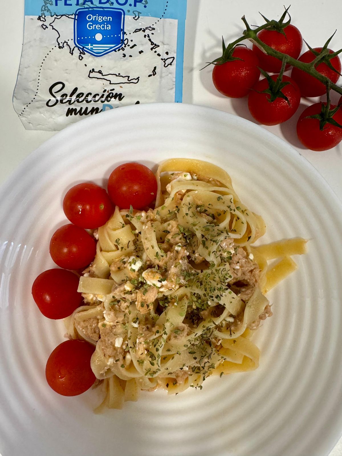 Prato de massa com tomate e queijo feta representando a refeição principal após a salada de entrada