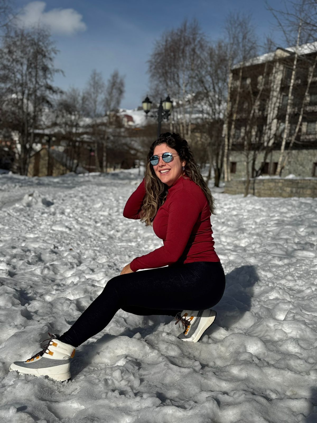 Pessoa sorrindo na neve, representando bem-estar e cuidados com a imunidade no inverno europeu